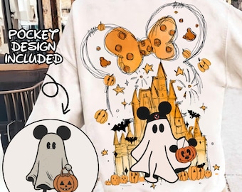 Könnte beinhalten: Weißer Pullover mit einer Cartoon-Illustration von Mickey Mouse, der als Geist verkleidet ist und einen Kürbis hält. Die Illustration enthält ein Schloss, Fledermäuse, Sterne und Feuerwerk. Der Text "POCKET DESIGN INCLUDED" ist in der oberen linken Ecke des Bildes sichtbar.