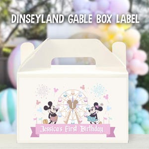 May include: A white gable box label with a pink and blue Disney theme. The label features Mickey and Minnie Mouse in front of a Ferris wheel with fireworks in the background. The text on the label reads "Jessica's First Birthday".