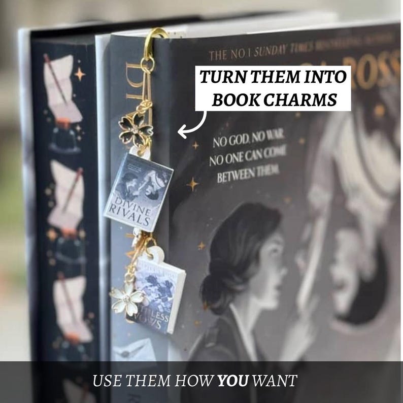 May include: A gold bookmark with a safety pin design, featuring miniature book charms and floral details. The charms display book covers with titles such as "Divine Rivals" and "Ruthless Vows." The image text reads "Turn them into book charms" and "Use them how you want."