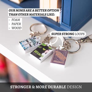 May include: Miniature book keyrings with silver rings. The keyrings feature book covers with titles like "Wicked" and "Wuthering Heights." Text on the image reads "Our minis are a better option than other materials like: foam, paper, wood." The design is described as "Stronger & More Durable Design."