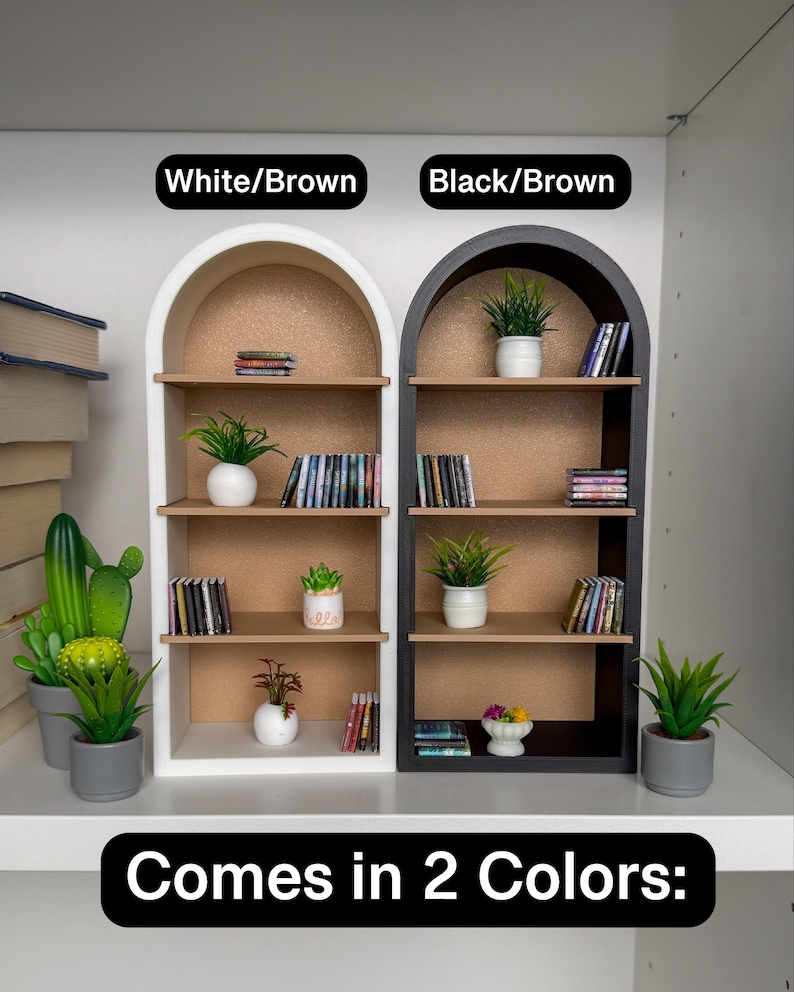 May include: Two arched shelves, one white and one black, with brown shelves and a corkboard back. Each shelf is decorated with potted plants and books. The text "White/Brown" and "Black/Brown" is above each shelf. The text "Comes in 2 Colors" is below the shelves.