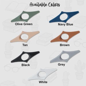 以下が含まれることがあります： オリーブグリーン、ネイビーブルー、タン、ブラウン、ブラック、グレー、ホワイトの様々な色のブックホルダーのセレクション。各アクセサリーは、円形の開口部を備えたユニークなデザインが特徴です。「Available Colors」の文字が上部にあります。