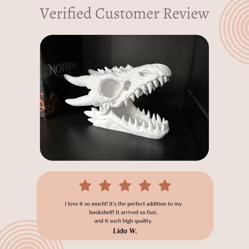 May include: A white dragon skull sculpture with sharp teeth and horns. The sculpture is displayed on a shelf with a book visible in the background. The image includes a customer review with five stars.