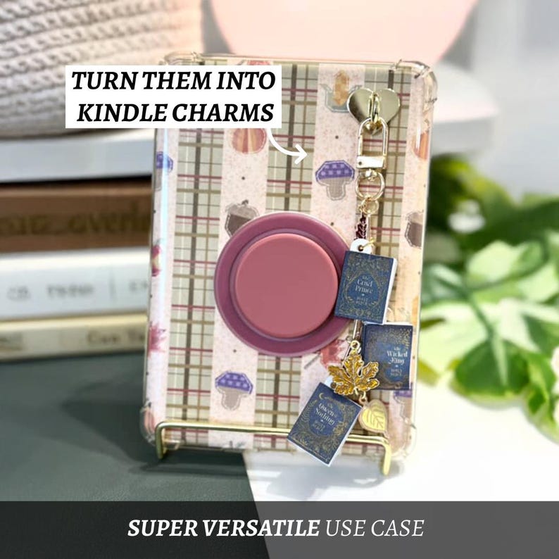 May include: A clear phone case with a plaid pattern, a pop socket, and a charm. The charm includes miniature book pendants and a gold leaf. Text on the case reads "TURN THEM INTO KINDLE CHARMS" and "SUPER VERSATILE USE CASE".