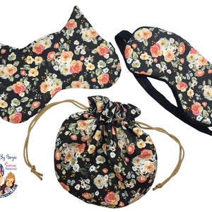 May include: A set of three sleep masks with a floral print on a black background. The masks are shaped like a cat, a traditional eye mask, and a drawstring pouch.