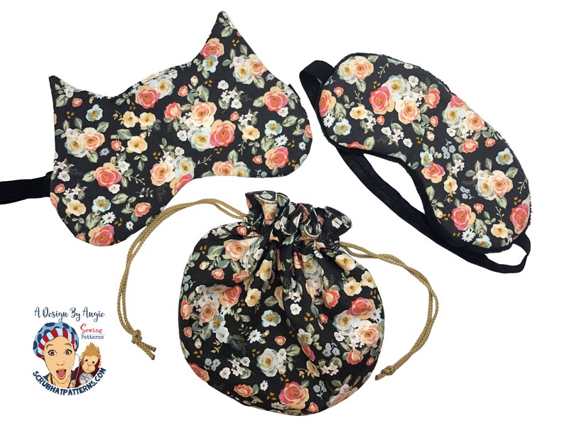 May include: A set of three sleep masks with a floral print on a black background. The masks are shaped like a cat, a traditional eye mask, and a drawstring pouch.