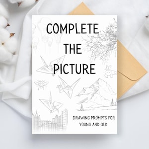 Op de afbeelding: Een witte kaart met de tekst "COMPLETE THE PICTURE" in zwart. De kaart heeft verschillende zwart-witte lijntekeningen, waaronder origami-kranen, een bij, een kat, een bergketen, een stadsbeeld en een tak. De tekst "DRAWING PROMPTS FOR YOUNG AND OLD" staat onderaan de kaart.