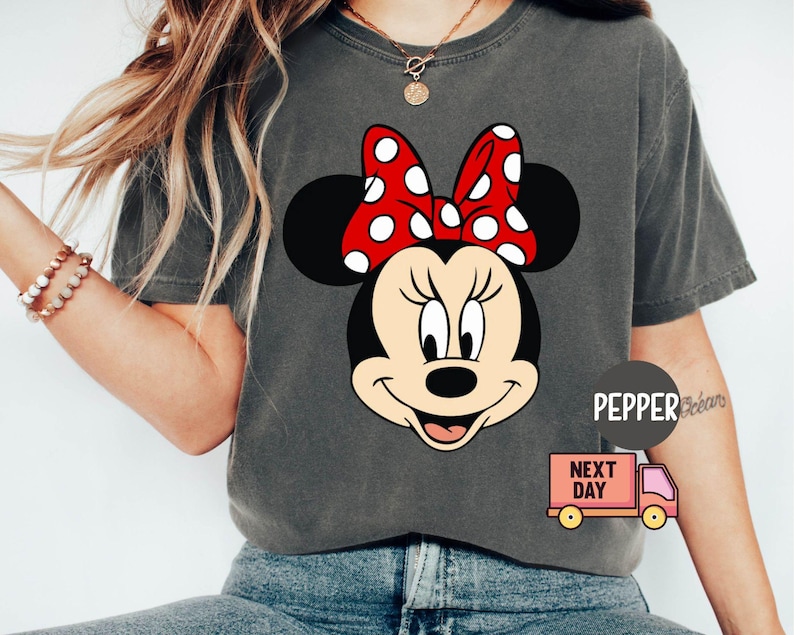 Może przedstawiać: Szara koszulka z czerwono-białym rysunkiem animowanym Myszki Miki. Na koszulce w lewym dolnym rogu znajduje się napis "Next Day".