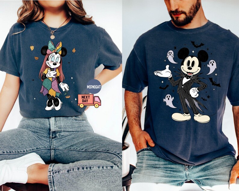May include: Two navy blue t-shirts featuring Disney characters. One shirt displays Minnie Mouse in a patchwork dress, the other features Mickey Mouse in a pinstripe suit with ghosts and bats. Both shirts are short-sleeved.