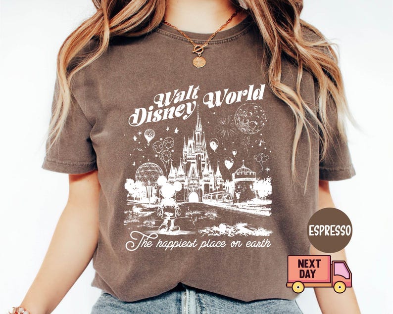 May include: Espresso-colored t-shirt featuring a white graphic of Cinderella's castle, Mickey Mouse, and the text "Walt Disney World" and "The happiest place on earth." The shirt has a vintage, distressed look.