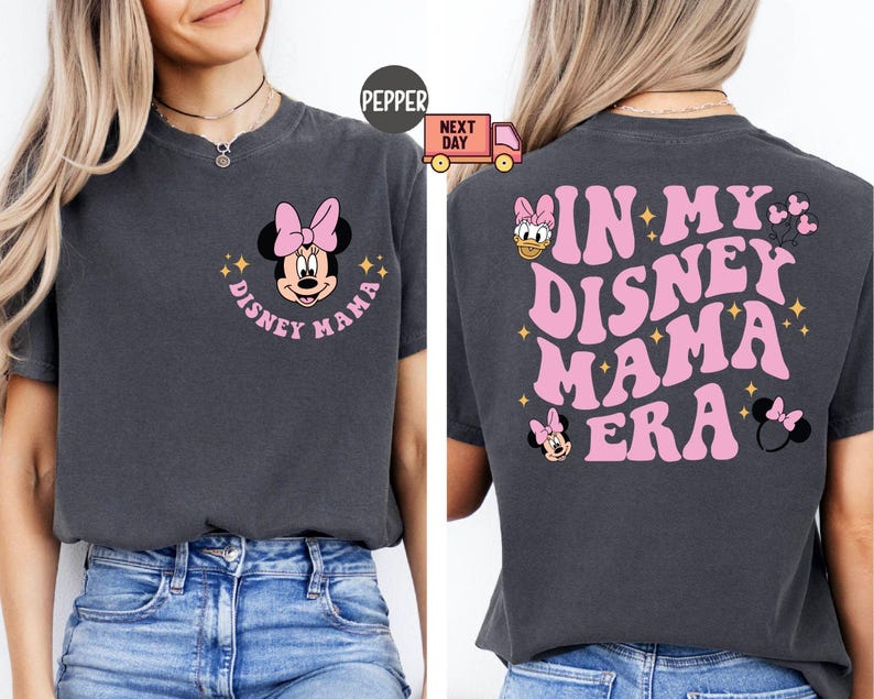 May include: Dark gray t-shirt with a pink Minnie Mouse graphic and the words "Disney Mama" in a circular design. The back of the shirt says "In My Disney Mama Era" in pink, with additional Disney character graphics.