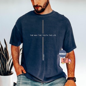 Puede incluir: Camiseta azul marino con el texto "THE WAY THE TRUTH THE LIFE" y una l&iacute;nea blanca vertical. El texto "JOHN 14:6" est&aacute; impreso verticalmente. La camiseta la lleva una persona.