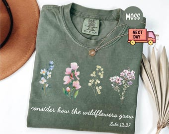 May include: A green t-shirt with a floral design and the text "consider how the wildflowers grow Luke 12:27".