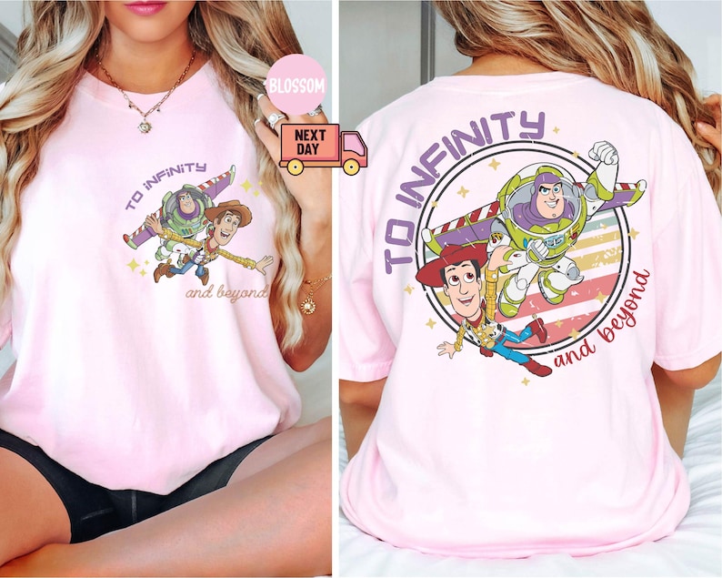 May include: Pink t-shirt with a graphic of Woody and Buzz Lightyear from Toy Story. The graphic says "To infinity and beyond".