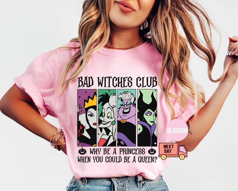May include: Pink t-shirt with the text "BAD WITCHES CLUB" above a graphic of four cartoon villains. Below the graphic is the text "WHY BE A PRINCESS WHEN YOU COULD BE A QUEEN?" A small pumpkin graphic is on either side of the text.