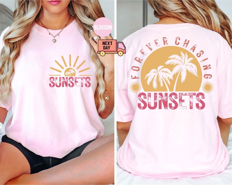 May include: A light pink t-shirt with a sunset graphic. The front of the shirt features the word "SUNSETS" in a distressed font, with a sun and palm trees. The back of the shirt says "FOREVER CHASING SUNSETS".