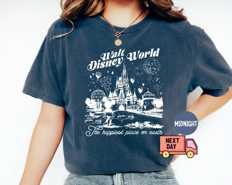 May include: Dark blue t-shirt featuring a white graphic of the Walt Disney World castle, Mickey Mouse, and fireworks. Text reads "Walt Disney World" and "The happiest place on earth".