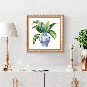 Puede incluir: Una pintura de acuarela de un jarr&oacute;n de porcelana azul y blanco con hojas verdes. El jarr&oacute;n tiene un dise&ntilde;o floral y est&aacute; sobre un fondo blanco.