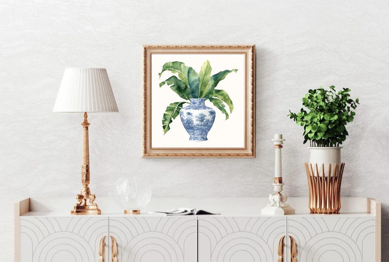 Puede incluir: Una pintura de acuarela de un jarr&oacute;n de porcelana azul y blanco con hojas verdes. El jarr&oacute;n tiene un dise&ntilde;o floral y est&aacute; sobre un fondo blanco.