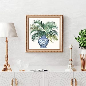 Puede incluir: Una pintura de acuarela de un jarr&oacute;n de porcelana azul y blanco lleno de hojas de palma verdes. El jarr&oacute;n est&aacute; decorado con un patr&oacute;n floral. La pintura est&aacute; enmarcada en un marco dorado.