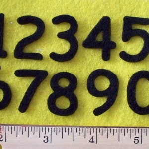 May include: Black felt numbers 1 through 10 on a yellow felt background. The numbers are approximately 2 inches tall.