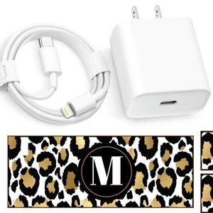 May include: White iPhone charger with a white cable and a leopard print phone case with the letter M in a circle.