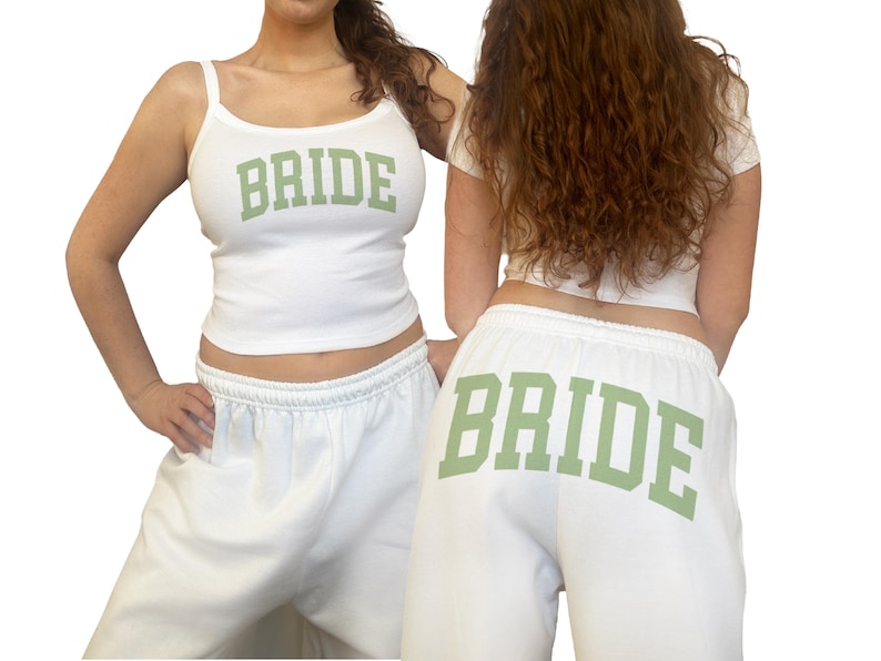May include: White tank top and sweatpants set with the word "BRIDE" in green block letters. The tank top has spaghetti straps, and the sweatpants have an elastic waistband. The outfit is perfect for a bachelorette party or bridal shower.