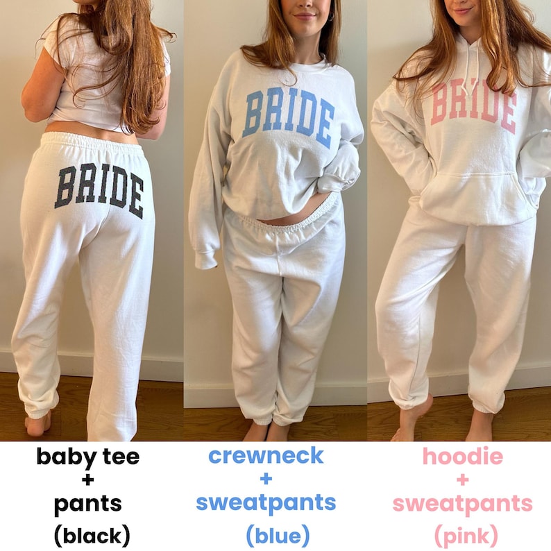 Pu&ograve; includere: Tre completi bianchi con la scritta "BRIDE" stampata. Il primo &egrave; una maglietta e pantaloni con testo nero. Il secondo &egrave; un girocollo e pantaloni della tuta con testo blu. Il terzo &egrave; una felpa con cappuccio e pantaloni della tuta con testo rosa.