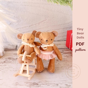 May include: Two brown teddy bear dolls with cream-colored lace collars. One doll sits on a wooden rocking horse, while the other wears a pink tutu. The image includes the text "Tiny Bear Dolls PDF pattern".