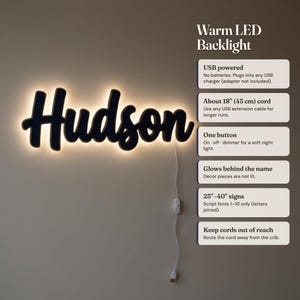 May include: A black script sign displaying the name Hudson with a warm LED backlight. The sign includes a white USB power cord with a single button for on, off, and dimmer functions. Text on the right details features like USB power and 45 cm cord.
