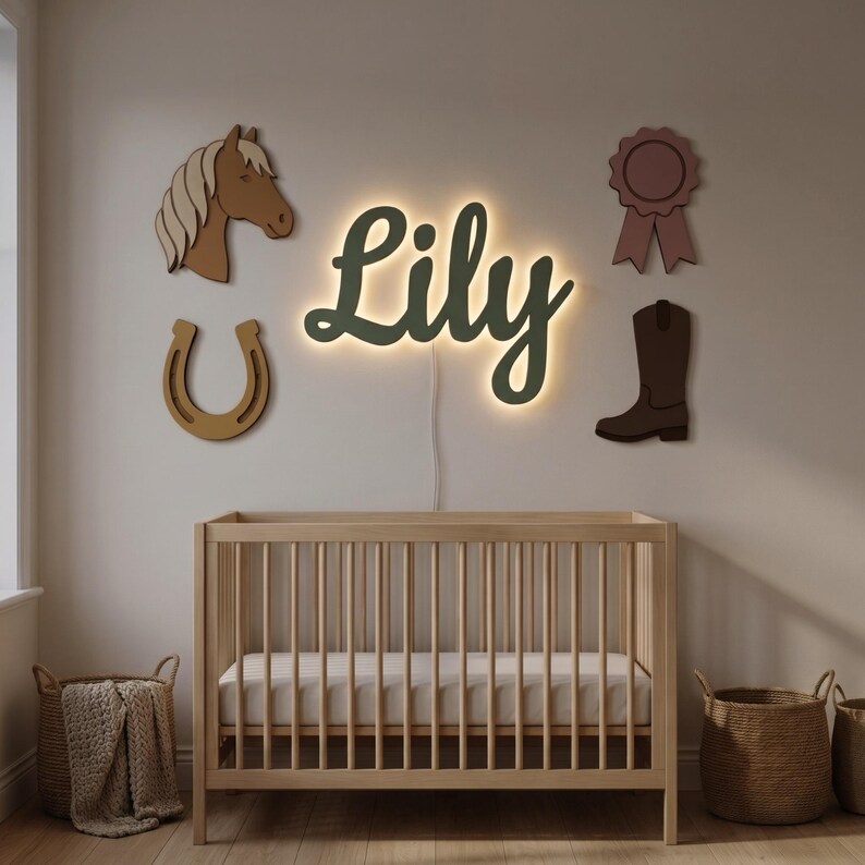 May include: A wall-mounted LED sign displaying the name Lily in dark green script with a warm backlight. Surrounding the sign are four wooden wall decorations: a brown horse head, a tan horseshoe, a dark brown cowboy boot, and a mauve ribbon.