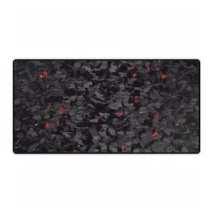 May include: A rectangular black desk mat with a textured surface. The mat features a pattern of dark grey and black shapes with small red accents scattered throughout. The mat has a black border.