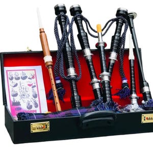 Puede incluir: Un juego de gaitas en un estuche negro con interior rojo. Las gaitas son negras con detalles plateados y elementos decorativos azules y morados. Se ve una hoja de papel con diagramas de digitación.