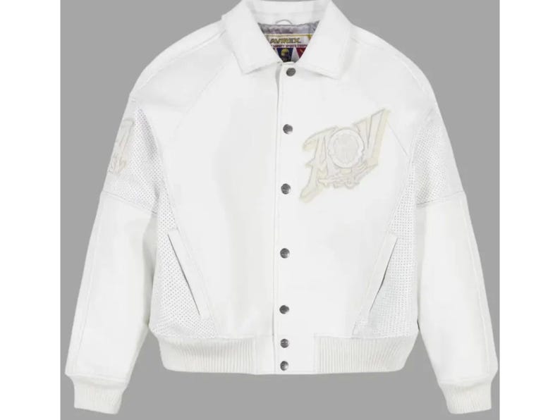 May include: A white varsity-style jacket featuring a classic collar, snap-button front closure, and ribbed cuffs and hem. The garment includes perforated side panels, two slanted front pockets, and a large embroidered patch on the left chest.
