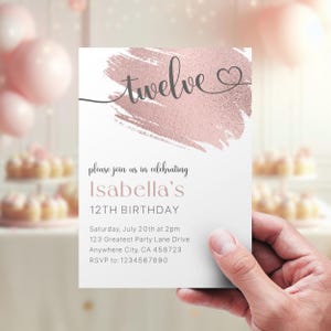 May include: A white invitation card with a pink and gold brushstroke design. The text "twelve" is written in cursive with a heart symbol. The invitation is for Isabella's 12th birthday party. The party details are listed below: Saturday, July 20th at 2pm, 123 Greatest Party Lane Drive, Anywhere City, CA 458723. RSVP to: 1234567890.