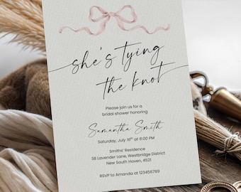 May include: A bridal shower invitation with the text "she's tying the knot" in elegant script. The invitation features a watercolor bow and ribbon design in a soft pink hue. Details include the honoree's name, date, time, and location.