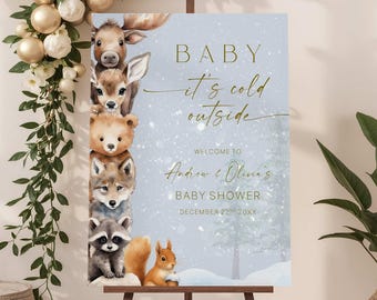 May include: A baby shower sign featuring watercolor illustrations of woodland animals, including a moose, deer, bear, fox, raccoon, and squirrel. The sign has the text "BABY it's cold outside" and welcomes guests to Andrew & Olivia's baby shower.