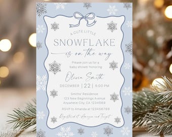 Op de afbeelding: Een uitnodiging voor een babyshower met een lichtblauwe achtergrond en sneeuwvlokaccenten. De tekst luidt "A Cute Little Snowflake is on the Way". De uitnodiging bevat de datum, tijd en locatie van het evenement, samen met de naam Olivia Smith.