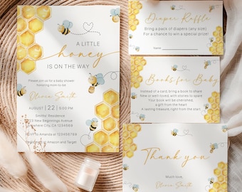 May include: A set of baby shower stationery with a bee theme. The invitation reads "A Little Honey is on the Way" with a honeycomb design and bee illustrations. Includes diaper raffle, books for baby, and thank you cards.