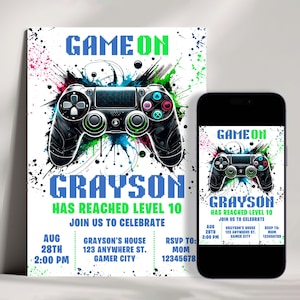 May include: A colourful invitation for a video game themed party. The invitation features a black PlayStation controller with colourful paint splatters in the background. The text "GAME ON" is in green and blue pixelated letters. The text "GRAYSON HAS REACHED LEVEL 10" is in blue pixelated letters. The text "JOIN US TO CELEBRATE" is in green pixelated letters. The invitation includes the date, time, and location of the party.