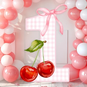 Könnte beinhalten: Aquarell-Illustration mit der Zahl eins, verziert mit einem rosa Vichy-Muster, einer rosa Schleife und zwei Kirschen. Der Hintergrund zeigt rosa und weiße Ballons, die eine festliche Szene schaffen.