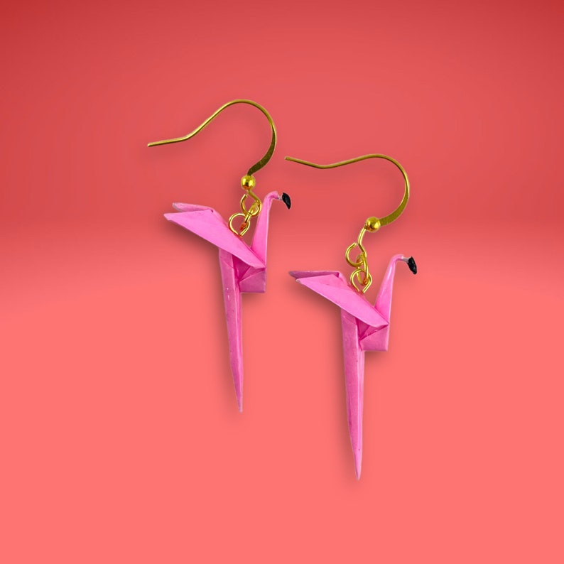 May include: A pair of pink origami flamingo earrings with gold hooks.