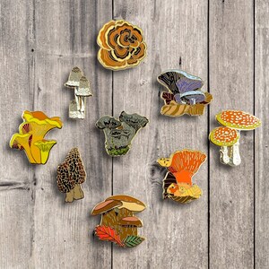 Pu&ograve; includere: Un set di dieci spille smaltate che raffigurano diversi tipi di funghi. Le spille sono colorate e dettagliate, con una variet&agrave; di forme e dimensioni. Le spille sono perfette per aggiungere un tocco di fantasia ai tuoi vestiti, borse o altri accessori.