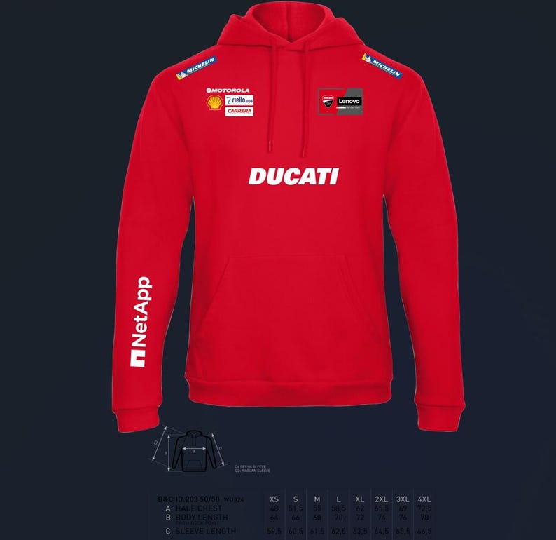 以下が含まれることがあります： フロントポケット付きの赤いドゥカティのパーカー。「DUCATI」の文字が胸に白でプリントされています。ミシュラン、モトローラ、シェル、レノボ、NetAppのロゴも表示されています。パーカーは長袖です。