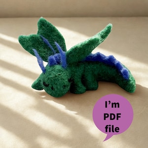 May include: A handmade felt dragon in shades of green and blue. The dragon has wings, a long tail, and small horns. A purple speech bubble with the text "I'm PDF file" is in the image.