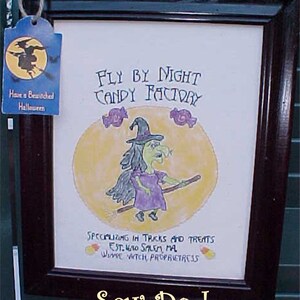 May include: A framed illustration of a witch flying on a broomstick with the text "Fly By Night Candy Factory" and "Specializing in Tricks and Treats Est. 1670 Salem, MA Wine Witch Proprietress". The image is set against a yellow moon with candy cane accents. The text "Sew Do I" is written below the frame.