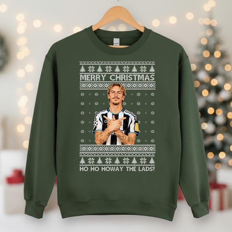 Puede incluir: Sudadera verde con un dise&ntilde;o festivo. La sudadera presenta un retrato de un hombre con los brazos cruzados, el texto "MERRY CHRISTMAS" y "HO HO HOWAY THE LADS!". El dise&ntilde;o incluye copos de nieve y &aacute;rboles de Navidad.