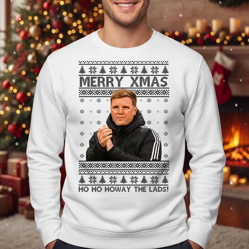 May include: White sweatshirt with a festive design. The sweatshirt features the text "MERRY XMAS" above an image of a man in a black jacket. Below the image is the text "HO HO HOWAY THE LADS!" with snowflake and tree patterns.