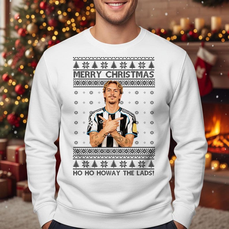 Puede incluir: Jersey navide&ntilde;o blanco con un dise&ntilde;o festivo. El jersey presenta el texto "MERRY CHRISTMAS" y "HO HO HOWAY THE LADS!". Tambi&eacute;n incluye un gr&aacute;fico de una persona con los brazos cruzados. El jersey tiene un patr&oacute;n de copos de nieve y &aacute;rboles de Navidad.