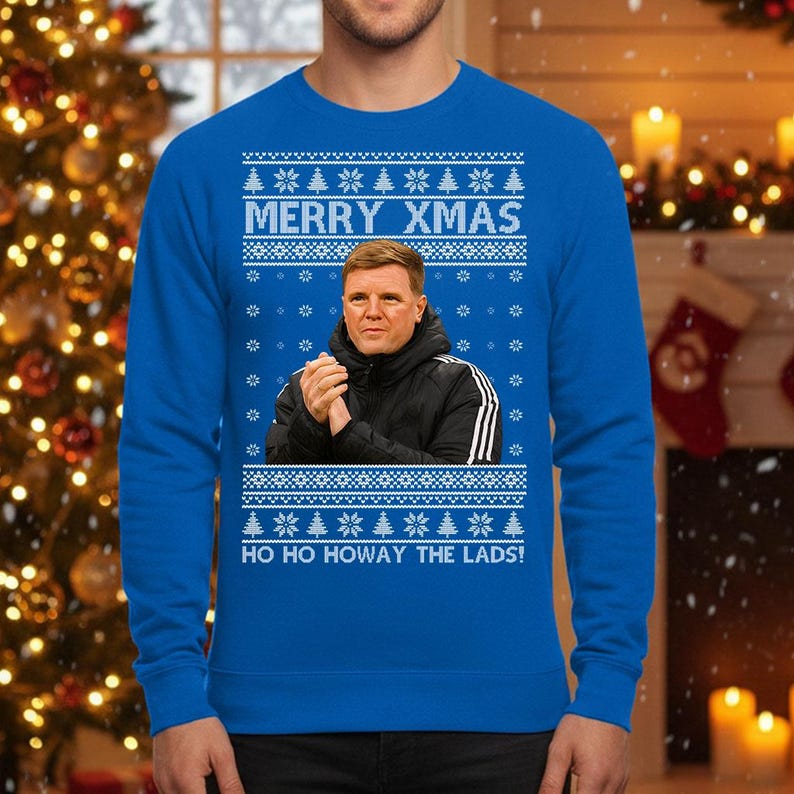 May include: A blue Christmas sweater with the text "MERRY XMAS" and "HO HO HOWAY THE LADS!". The sweater features a portrait of a man in a black jacket. The design includes snowflakes and Christmas trees.